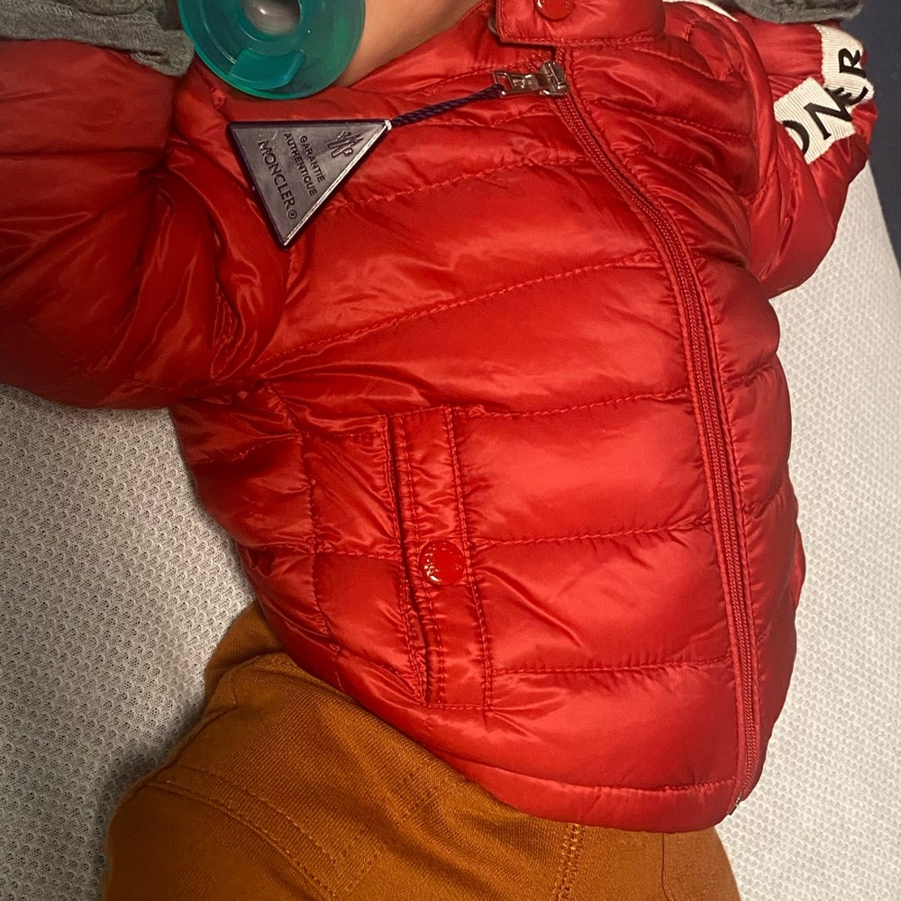 I’m selling a MONCLEAR Infant Coat 6-9 Months With Hat Included